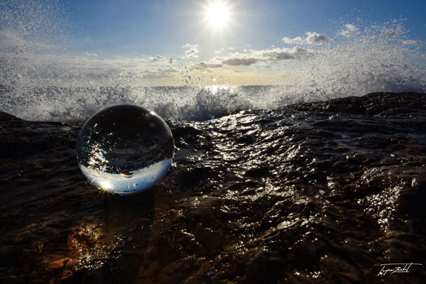 Création photo avec une boule de cristal en bord de mer